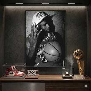 a framed black and white photograph of a basketball player, along with a trophy, a basketball, and a pair of sneakers on a wooden shelf.