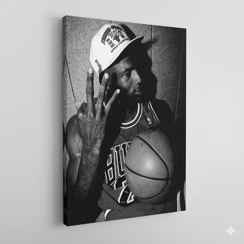A black and white portrait of a basketball player wearing a Chicago Bulls jersey and a white cap, holding a basketball and making a peace sign gesture.