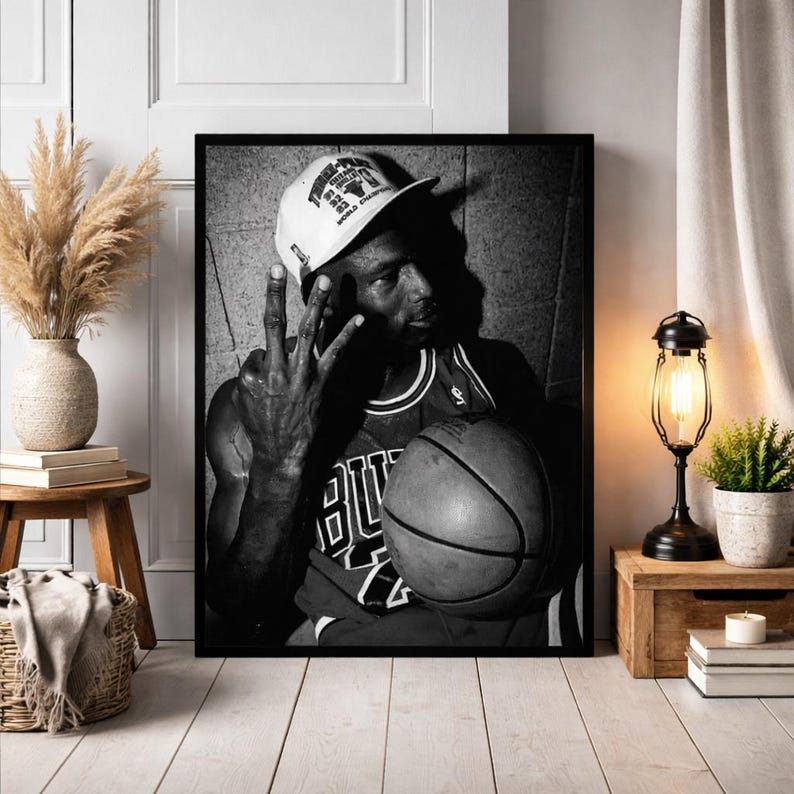 A framed black and white photograph of a basketball player, likely Michael Jordan, holding a basketball and making a peace sign gesture.
