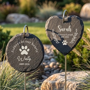 Op de afbeelding: Twee gedenkstenen voor in de tuin, één rond en één hartvormig, met gegraveerde tekst en pootafdrukken. De ronde steen leest "Forever in our hearts" en "Wally 2009-2026." De hartvormige steen zegt "Sarah Forever Loved 2009-2026."