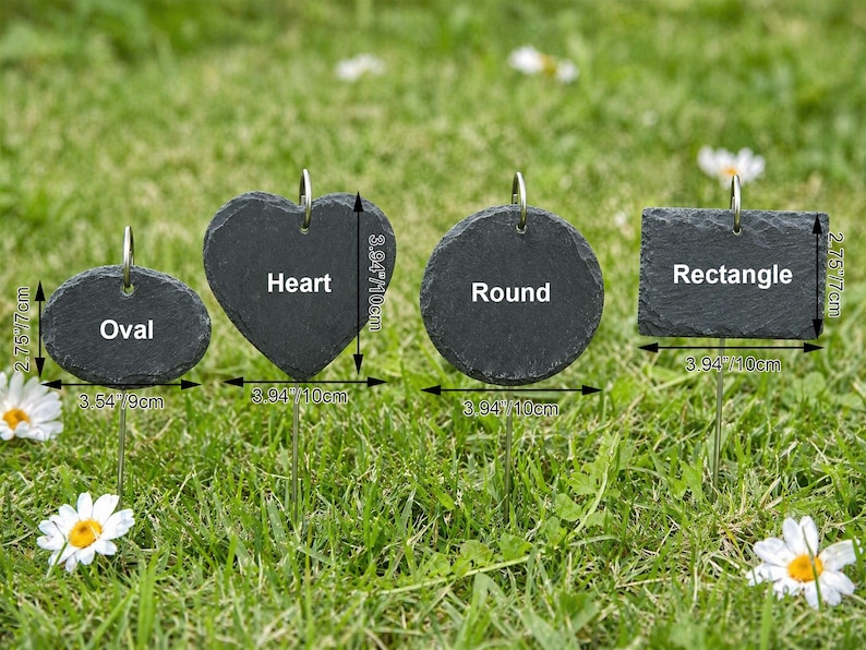May include: Four dark gray slate garden markers in oval, heart, round, and rectangular shapes, each with a metal loop for hanging. The oval is 3.54 inches wide, the heart and round are 3.94 inches wide, and the rectangle is 3.94 inches wide.