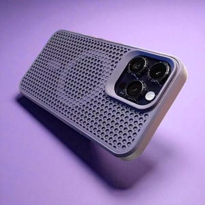 May include: A lavender phone case with a perforated design and a camera module featuring three lenses. The case has a light-colored border and is set against a purple background. The case is designed to protect the phone.