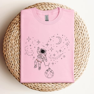 Cosmic Astronaut Graphic Tee: Starry Galaxy Universe Shirt