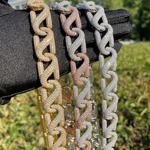 Puede incluir: Primer plano de tres collares de cadena con incrustaciones de diamantes en oro, oro rosa y plata. Las cadenas tienen un diseño entrelazado único. Los collares se muestran sobre un fondo negro.