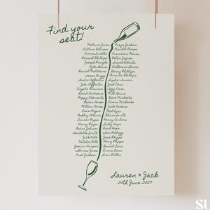 May include: A cream-colored wedding seating chart with green calligraphy. The design features a bottle pouring into a wine glass, with guest names listed below. The names are arranged in a flowing, vertical pattern.