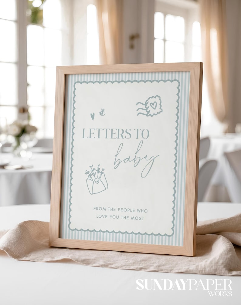 May include: A framed sign with the text "LETTERS TO baby" in a light blue script font. The sign has a light blue striped background and decorative border. The frame is made of light-coloured wood. The text "FROM THE PEOPLE WHO LOVE YOU THE MOST" is also included.