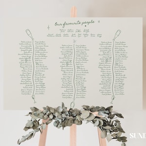 Peut inclure: Un panneau de plan de table de mariage rectangulaire blanc avec le texte "Our favourite people" en haut. Le panneau présente des illustrations au trait vert foncé de bouteilles et de verres de vin, avec des listes de noms en colonnes.