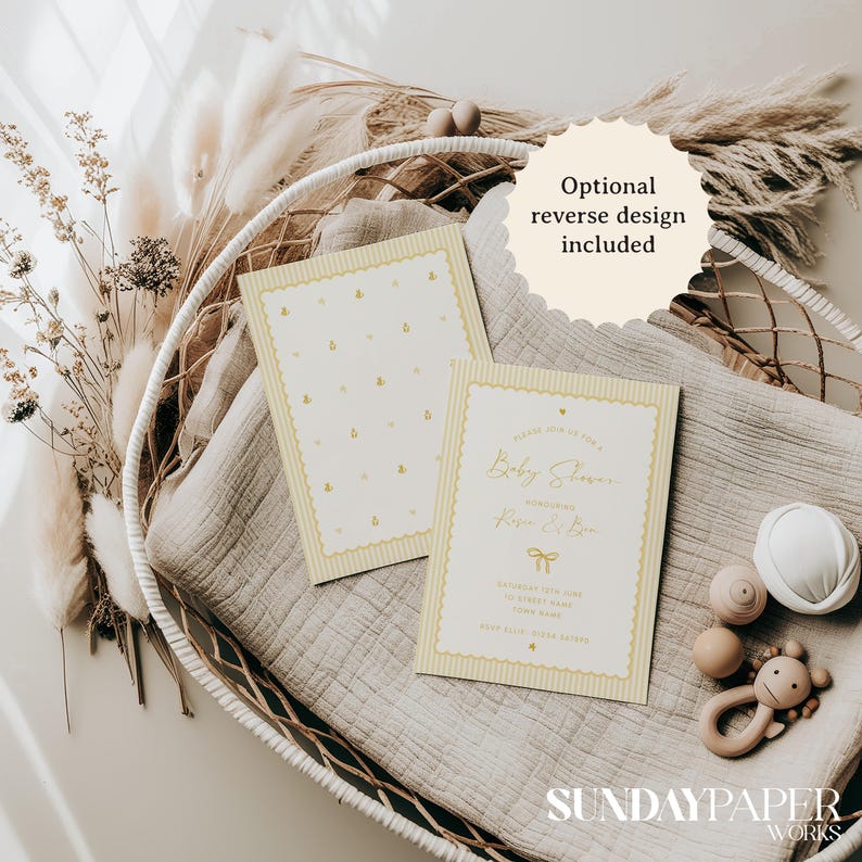 Może przedstawiać: Zaproszenia na baby shower w miękkich odcieniach ż&oacute;łci i bieli. Zaproszenia mają wz&oacute;r pszcz&oacute;ł i elegancki kr&oacute;j pisma. Widoczny jest tekst "Optional reverse design included". Zaproszenia są prezentowane z zabawkami dla dzieci i elementami dekoracyjnymi.