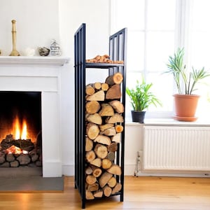 May include: A black metal log store filled with cut logs. The rectangular rack has vertical bars and a top shelf. The logs are various sizes and shapes, with visible wood grain. The rack is indoors near a fireplace.