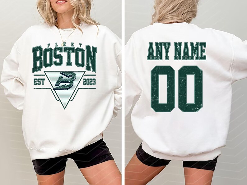 May include: White sweatshirt with "BOSTON" in green block letters, a logo, and "EST 2023". The back features "ANY NAME" above a green number "00". The sweatshirt is a casual style.