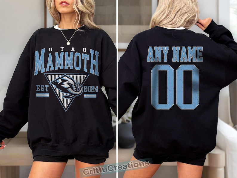 Puede incluir: Sudadera negra con "UTAH MAMMOTH" en letras azul claro y un logotipo del equipo. La parte trasera presenta "ANY NAME" y el n&uacute;mero "00" en azul claro. La sudadera tiene cuello redondo blanco.