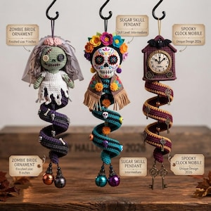 Op de afbeelding: Drie hangende gehaakte ornamenten: een zombiebruid van 23 cm met sluier, een suikerschedelhanger met kleurrijke bloemen en een griezelige klokmobiel met een vleermuis en sleutels. Elk ornament heeft een spiraalvormige basis en decoratieve details.