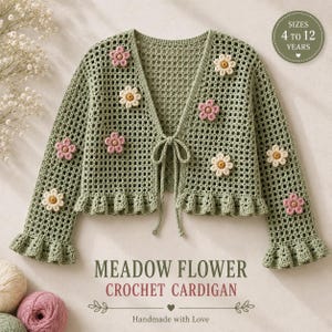 Può includere: Un cardigan all'uncinetto verde salvia con motivo a griglia, maniche lunghe con polsini a volant e chiusura frontale a fiocco. Il capo è decorato con piccoli fiori tridimensionali rosa e bianchi. Testo: SIZES 4 TO 12 YEARS, MEADOW FLOWER CROCHET CARDIGAN, Handmade with Love.