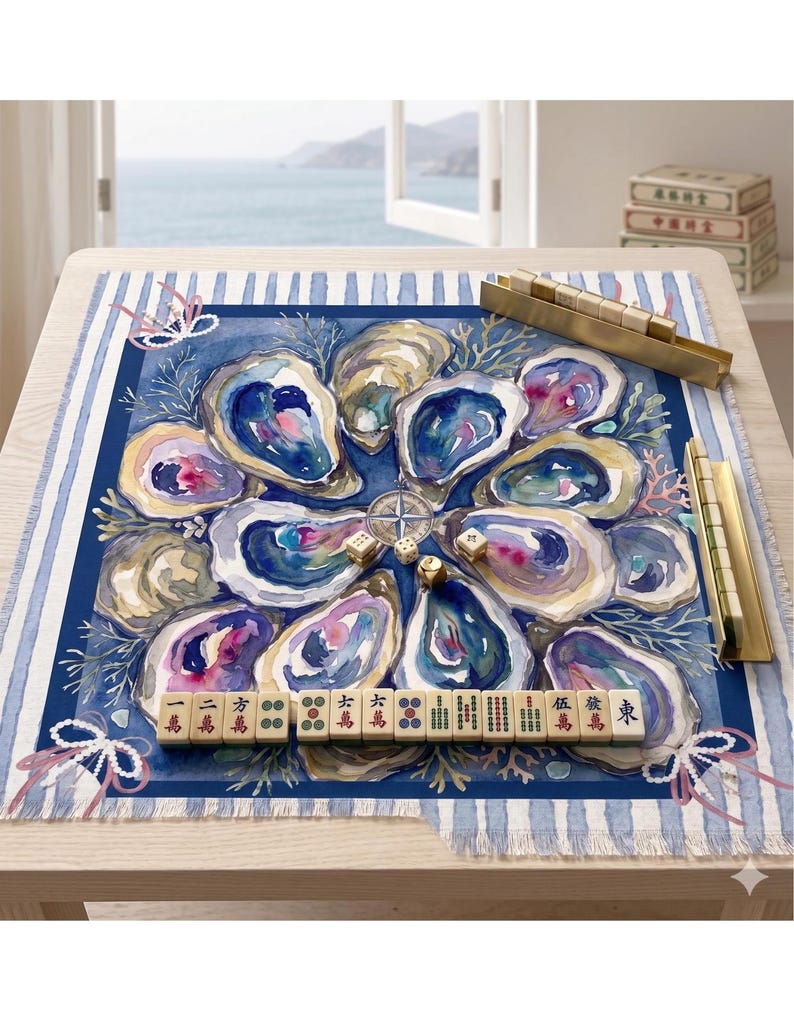 May include: A square fabric game mat featuring a watercolor illustration of blue and purple oysters and coral. The mat includes a central compass rose, scattered dice, and a row of mahjong tiles with Chinese characters and symbols.