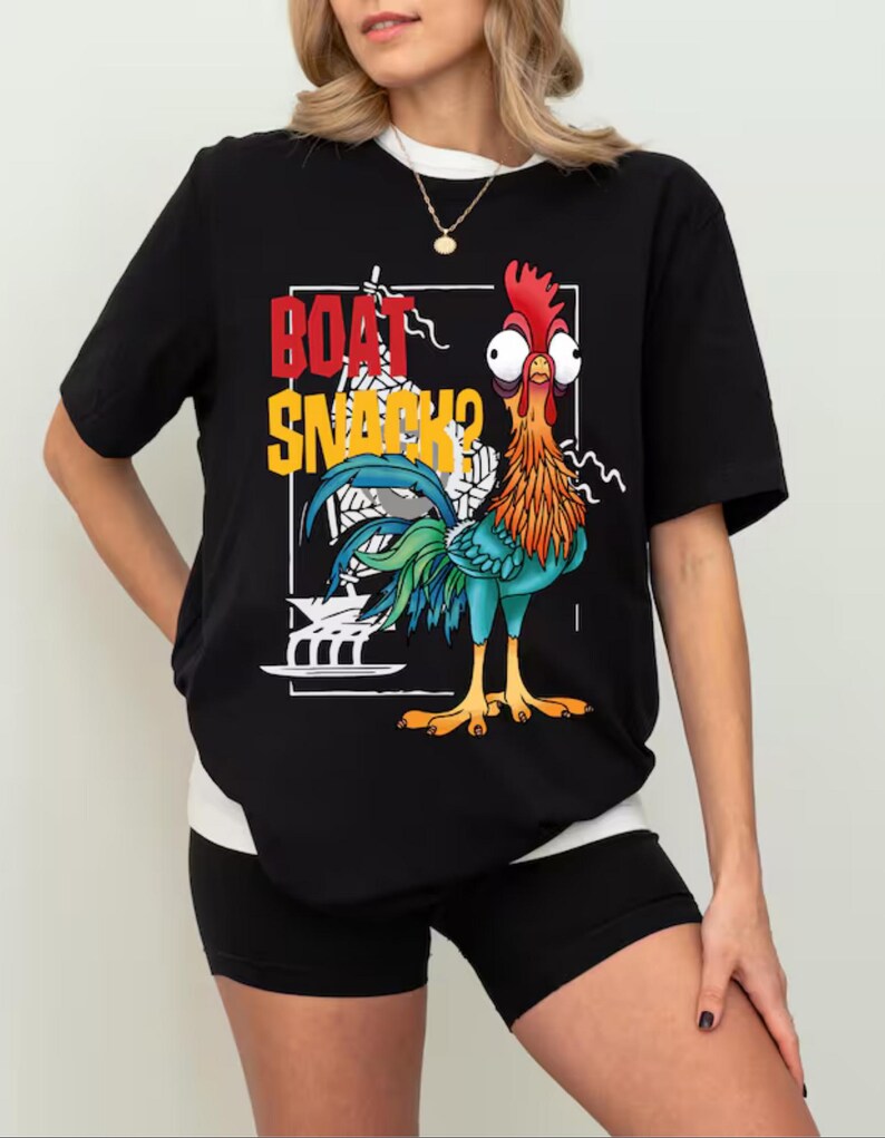 Puede incluir: Camiseta negra con un dise&ntilde;o de gallo de dibujos animados y el texto "BOAT SNACKS?". El gallo tiene plumas rojas, naranjas, azules y verdes. La camiseta tiene cuello blanco y se combina con pantalones cortos negros.