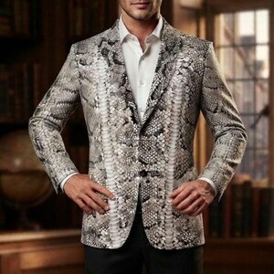 Peut inclure: Un blazer à motif peau de serpent gris et blanc, porté sur une chemise blanche à boutons. L'ensemble est complété par un pantalon noir uni et des bottines en cuir noir brillant, créant une apparence nette et structurée.