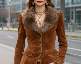 May include: A brown suede jacket featuring a large faux fur collar, long sleeves with fur-trimmed cuffs, and a front button closure with gold-toned buttons. The jacket includes two front flap pockets and intricate embroidery details on the cuffs.