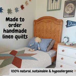 May include: A handmade linen quilt with a starburst pattern in shades of beige, rust, and green. The bed is made up with a striped pillow and a doll. The text on the image says "Made to order handmade linen quilts".