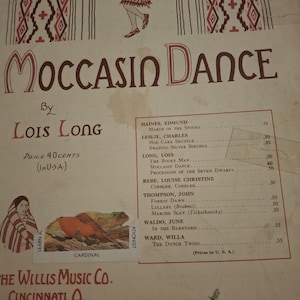 May include: Sheet music cover for "Moccasin Dance" by Lois Long. The title is in large, stylized letters. An illustration of a Native American figure with a spear and shield is at the top. The cover also includes a list of songs and the price.