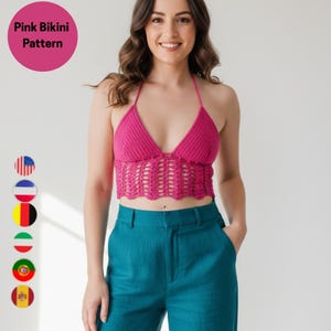 May include: A bright pink, halter-style crochet top with a scalloped hem. The top is paired with teal-colored pants. The image includes the text "Pink Bikini Pattern" in a pink circle.