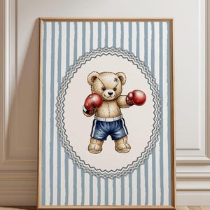May include: A framed print featuring a boxing teddy bear. The bear, with a stitched scar, wears red boxing gloves and blue shorts. The background has a light blue and white striped pattern, framed by a wooden border.