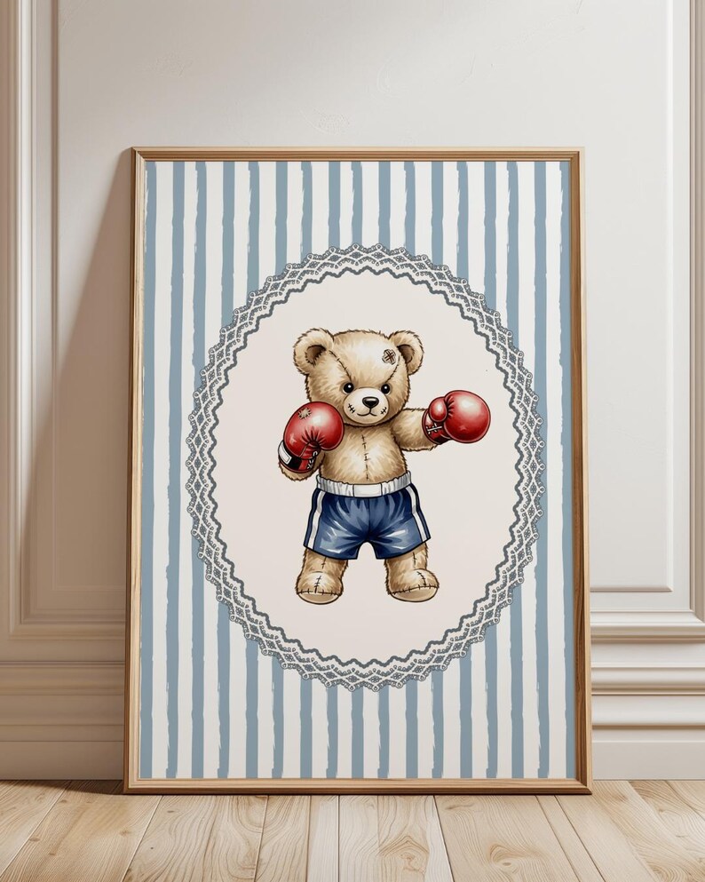 May include: A framed print featuring a boxing teddy bear. The bear, with a stitched scar, wears red boxing gloves and blue shorts. The background has a light blue and white striped pattern, framed by a wooden border.