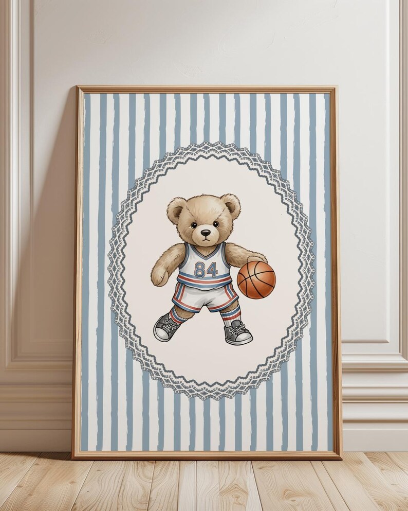 May include: A framed print featuring a teddy bear in a basketball uniform, holding a basketball. The bear wears a white and blue jersey with the number 84. The background has blue and white vertical stripes, framed in a wooden frame.