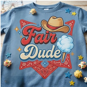 May include: A blue t-shirt featuring a graphic print with the text Fair Dude in red and cream lettering. The design includes a tan cowboy hat, a light blue cotton candy cone, red bandana-patterned accents, and small yellow and blue star shapes.
