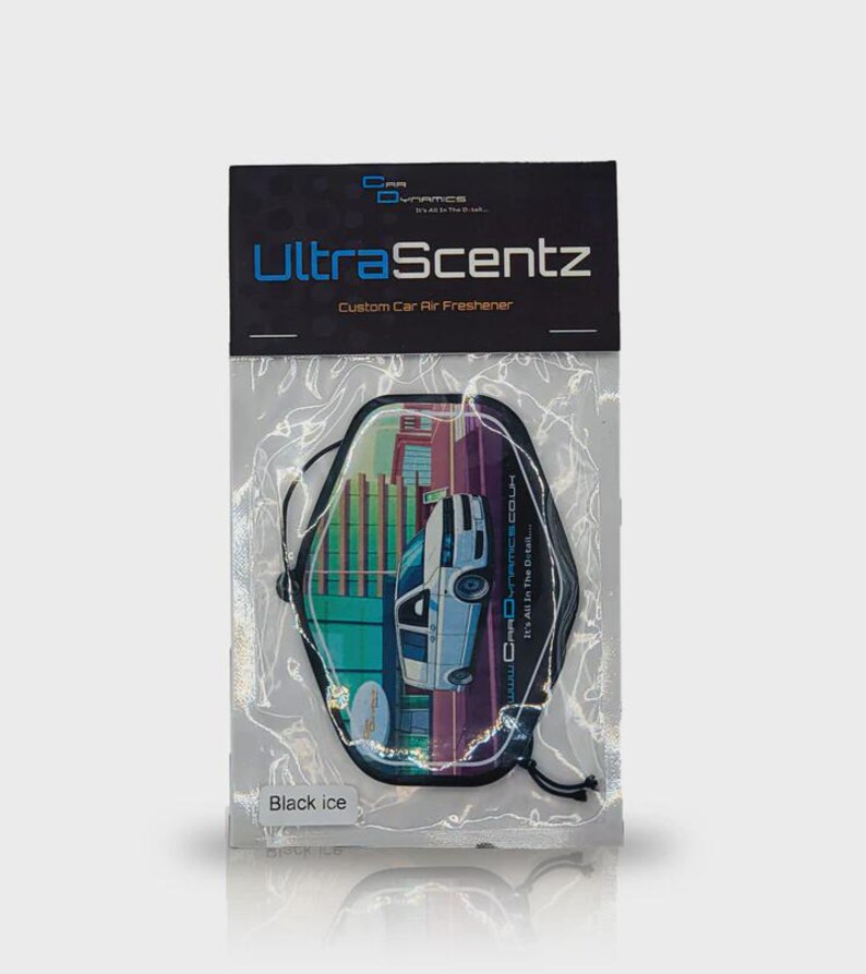 May include: A car air freshener in a clear plastic package. The product is labeled "UltraScentz" and "Custom Car Air Freshener." The air freshener has a graphic of a car in front of a city skyline. The scent is "Black ice."