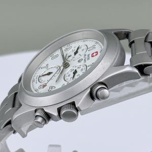 Puede incluir: Un reloj cron&oacute;grafo Swiss Military plateado con esfera blanca. El reloj presenta m&uacute;ltiples subesferas, visualizaci&oacute;n de fecha y correa de acero inoxidable. Dise&ntilde;o cl&aacute;sico y funcional.