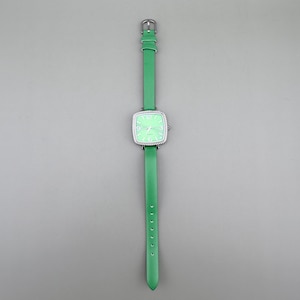 May include: A green wristwatch with a square face and a silver bezel. The watch has a light green face with white numerals and hands. The watchband is green leather. The watch is displayed against a grey background.