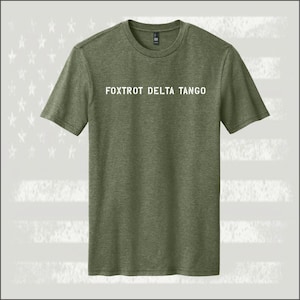 May include: A green t-shirt with the text "FOXTROT DELTA TANGO" printed in white on the front.
