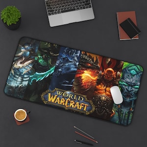 May include: A rectangular World of Warcraft mousepad featuring various characters and the game's logo. The design showcases a collage of fantasy figures in shades of blue, green, orange, and black. A white computer mouse rests on the pad.