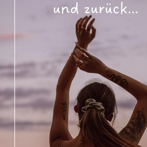 Può includere: Una donna con lunghi capelli castani legati con un elastico, indossa una canottiera bianca e sta in piedi con le braccia alzate contro un cielo di tramonto viola e rosa. Il testo "NARZISSMUS... einmal Hölle und zurück..." è scritto in bianco su sfondo nero nella parte superiore dell'immagine.