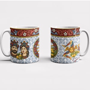 May include: Two white ceramic mugs with a colorful design. One mug features a royal couple with a crown and lemons. The other mug features a three-legged figure with wings and lemons. Both mugs have a red, gold, and blue border.
