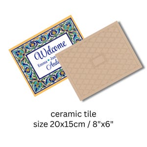 K&ouml;nnte beinhalten: Keramikfliese mit dekorativem Blumenrand in Blau, T&uuml;rkis und Gelb. Die Fliese tr&auml;gt das Wort "Welcome" und Namen. Die Fliese misst 20x15cm. Eine zweite Fliese mit einem beigen geometrischen Muster ist ebenfalls abgebildet.