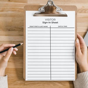 Könnte beinhalten: Ein Klemmbrett mit einem Besucher-Anmeldeformular. Das Formular hat Linien zum Ausdrucken eines Namens sowie Datum und Uhrzeit. Eine Hand hält einen Bleistift, bereit zum Schreiben. Das Klemmbrett liegt auf einer Holzoberfläche.
