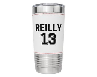 May include: White stainless steel tumbler with a white leather wrap. The wrap has black text that reads "REILLY 13".