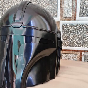 May include: A glossy black helmet with a distinctive visor and a rounded top. The helmet has a smooth, reflective surface and appears to be made of a durable material. The design suggests a futuristic or science fiction theme.