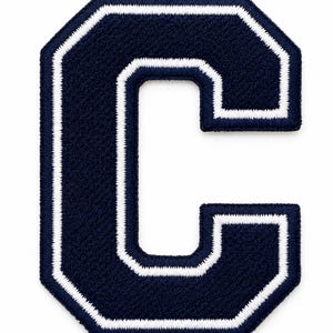 May include: A navy blue embroidered patch in the shape of the letter C. The letter features a thick navy blue center with a white border outline and a navy blue outer edge, all finished with a dense, textured thread embroidery technique.