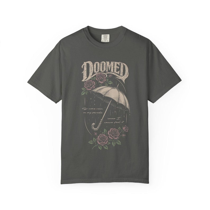 pepper color Comfort Colors T-shirt featuring a vintage gothic umbrella illustration with roses and rain details and the word “Doomed” in distressed lettering.