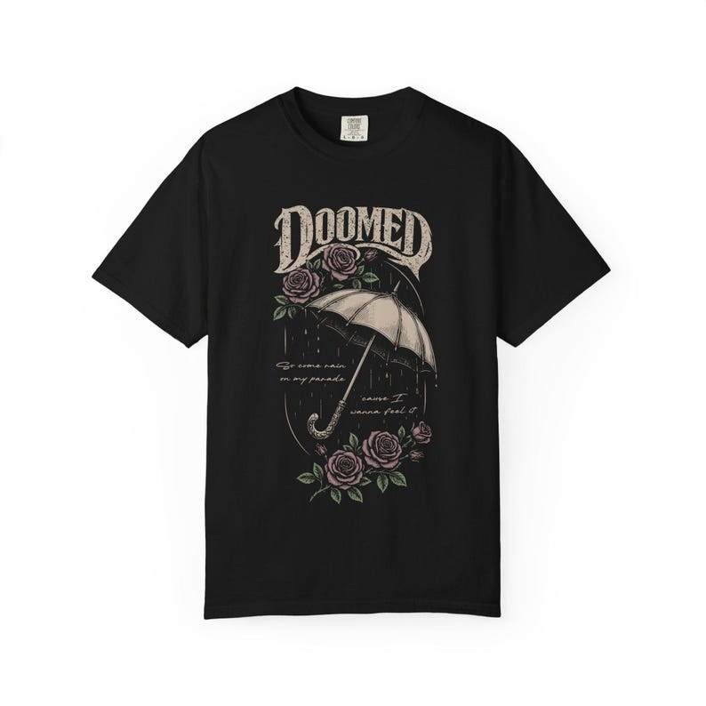 Black color Comfort Colors T-shirt featuring a vintage gothic umbrella illustration with roses and rain details and the word “Doomed” in distressed lettering.