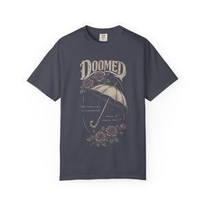 Navy color Comfort Colors T-shirt featuring a vintage gothic umbrella illustration with roses and rain details and the word “Doomed” in distressed lettering.