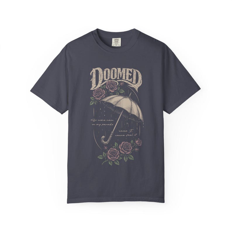 Navy color Comfort Colors T-shirt featuring a vintage gothic umbrella illustration with roses and rain details and the word “Doomed” in distressed lettering.