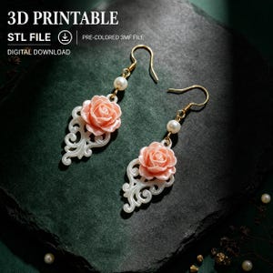 May include: A pair of drop earrings featuring a peach-colored rose above a white filigree scroll design, accented with a small white pearl bead and a gold-tone hook. The image includes the text 3D PRINTABLE, STL FILE, and DIGITAL DOWNLOAD.