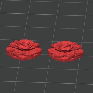 K&ouml;nnte beinhalten: Zwei identische, rosenf&ouml;rmige Objekte mit geschichteten, skulptierten Bl&uuml;tenbl&auml;ttern. Das Design zeigt eine zentrale Bl&uuml;te, die von wirbelnden, organischen Bl&uuml;tenblattmustern umgeben ist, dargestellt als 3D-Modell auf einem grauen Raster.