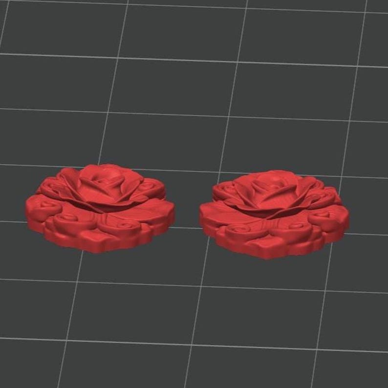 K&ouml;nnte beinhalten: Zwei identische, rosenf&ouml;rmige Objekte mit geschichteten, skulptierten Bl&uuml;tenbl&auml;ttern. Das Design zeigt eine zentrale Bl&uuml;te, die von wirbelnden, organischen Bl&uuml;tenblattmustern umgeben ist, dargestellt als 3D-Modell auf einem grauen Raster.
