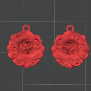 K&ouml;nnte beinhalten: Zwei identische rote Anh&auml;nger in Rosenform mit detaillierten, geschichteten Bl&uuml;tenbl&auml;ttern und einer runden &Ouml;se an der Oberseite zur Befestigung. Das Design zeigt eine zentrale bl&uuml;hende Rose, umgeben von wirbelnden, dekorativen Mustern in Rot.