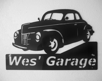 May include: Black metal silhouette of a vintage car with the words "Wes' Garage" on a black metal sign below.