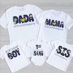 Puede incluir: Camisetas blancas y un body con diseños a juego. Las camisetas dicen "DADA", "MAMA", "BIRTHDAY BOY" y "SIS", con "of the birthday boy" debajo. El body dice "1ST Trip around the SUN".